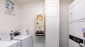 A laundry room with washers, dryers, and a bar. - Enjoy Affordable Comfort | 2 Units in Central Irving | Pet-Friendly Stay (Irving)