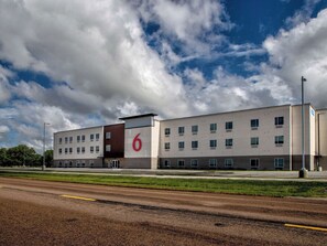 A modern building with a prominent '6' sign, multiple windows, and a flat roof.