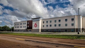 A modern building with a prominent '6' sign, multiple windows, and a flat roof.