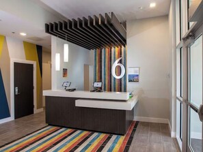 Una reception dal design moderno, con un grande numero '6' appeso al muro e un tappeto a righe.