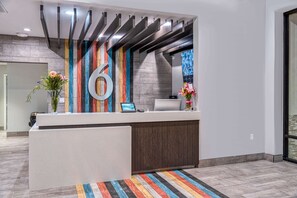A reception desk with a large number '6' on the wall, a computer, and a phone. - 3 Modern Rooms Near Children's Museum of Stockton - 0.4 mile | Parking Available (Stockton)