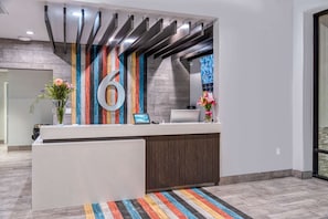 A reception desk with a large number '6' on the wall, a computer, and a phone. - 4 Pet-Friendly Rooms w/ Outdoor Pool Access and Near the Haggin Museum - 1.9 mi (Stockton)