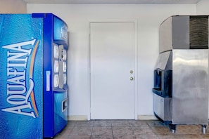 A water dispenser, a door, and a stainless steel appliance in a room.