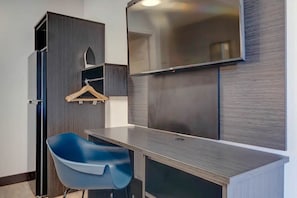 Une pièce comprenant un bureau, une chaise, une armoire et un miroir.