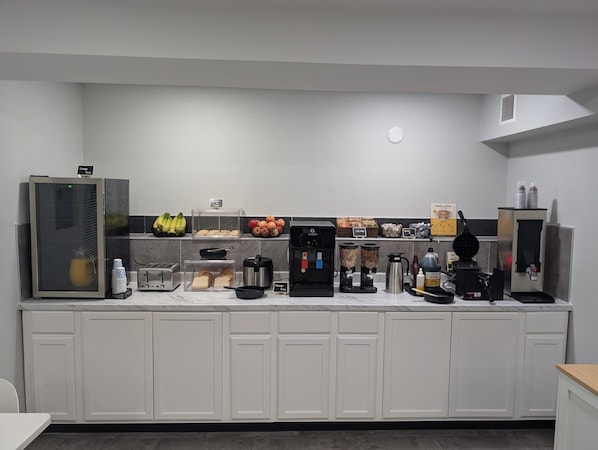 Une petite cuisine équipée d’une machine à café, d’un grille-pain, d’un mixeur et d’un réfrigérateur.