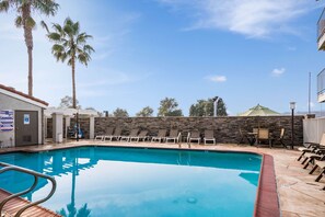 A swimming pool with lounge chairs, a stone wall, and palm trees. - 3 Welcoming Rooms Near American Armory Museum - 3.4 miles | Onsite Outdoor Pool (Fairfield)