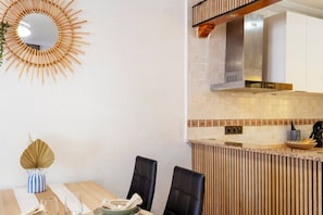 Eine moderne Küche mit Holzarbeitsplatte, Einbauherd und einem an der Wand befestigten Spiegel.