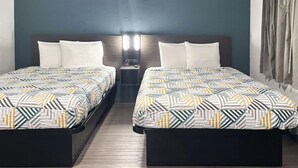 A hotel room with two beds, a nightstand, and a wall-mounted lamp. - 2 King Beds w/ Kitchen | Near Dallas Fort Worth International Airport - 2.4 mi (Irving)
