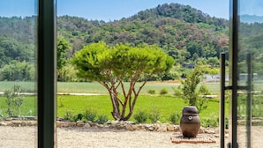 A view of a tree, a pot, and a field through a window. - Gyeongju Cheongbori Stay Pension (Gyeongju)