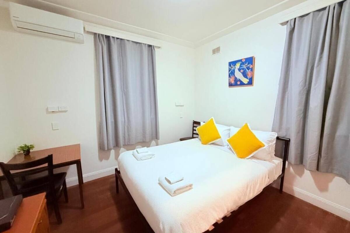A hotel room with a bed, a desk, and a chair.