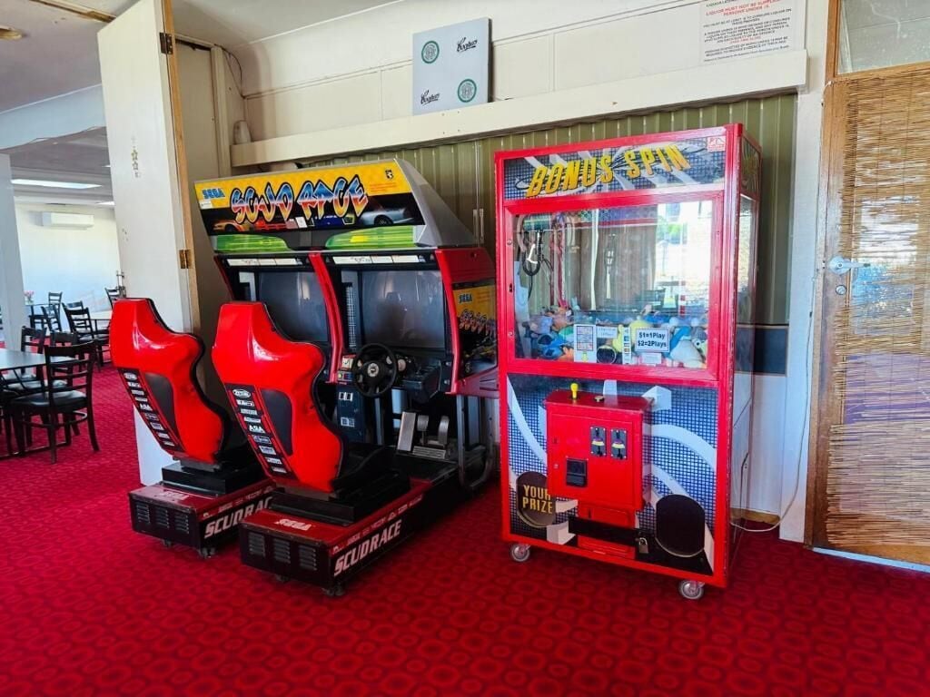 Dos máquinas recreativas, un juego de carreras rojo y negro, y un juego 'BONUS SPIN' rojo y azul.