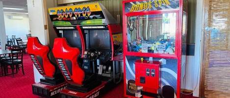 Dos máquinas recreativas, un juego de carreras rojo y negro, y un juego 'BONUS SPIN' rojo y azul.