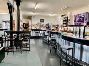 Zona de bar con taburetes, una barra y un calentador negro grande.