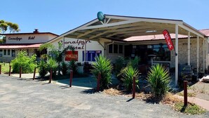A hotel with a covered entrance, a sign for 'Pokies,' and a red flag. - Coonalpyn Hotel (Coonalpyn)
