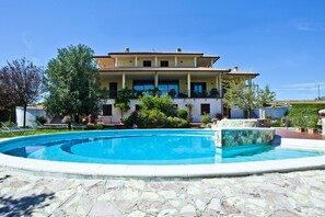 Un bâtiment à deux étages avec une piscine devant.