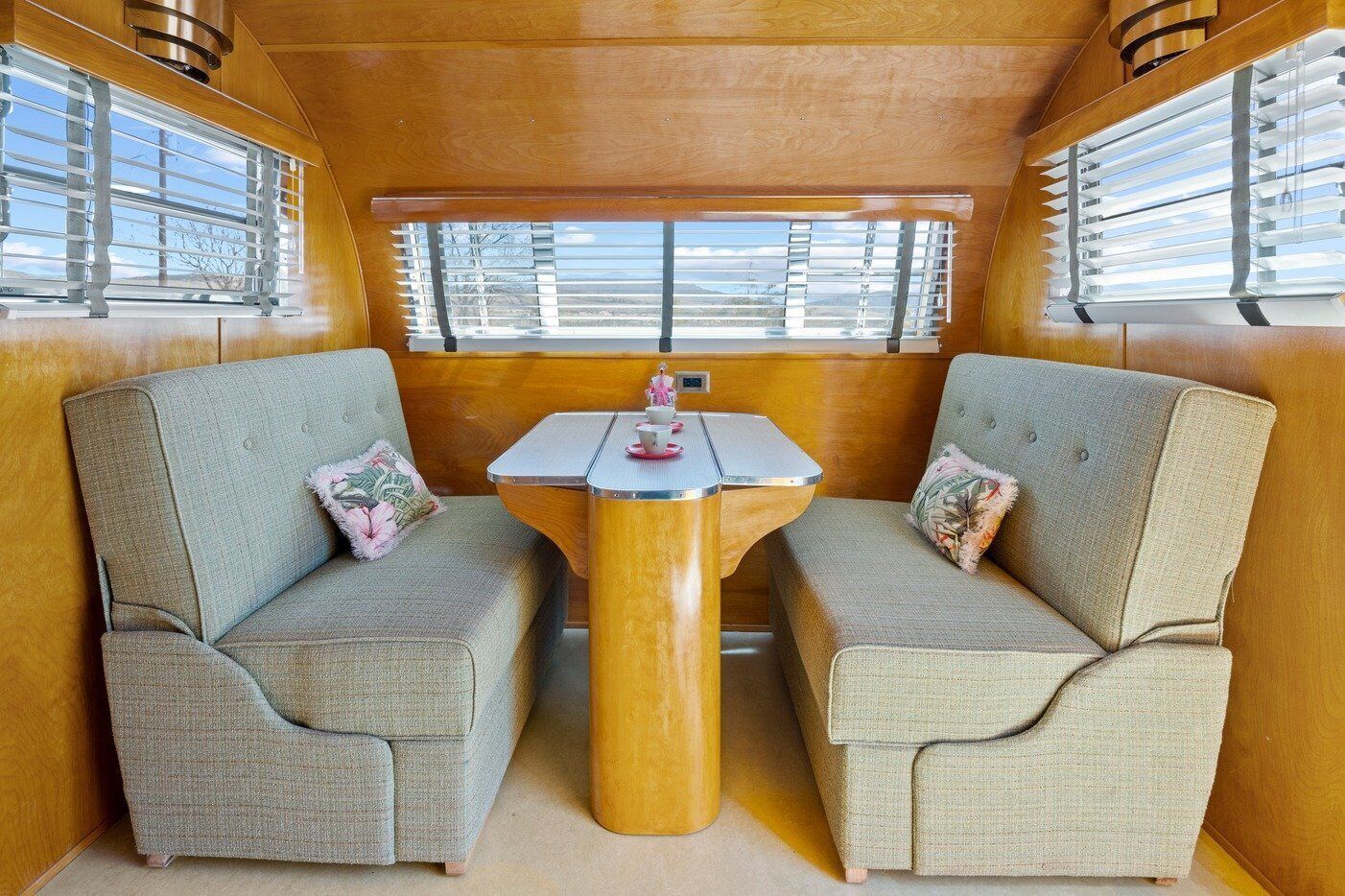 A cozy interior with two upholstered chairs, a small table, and a window with blinds.