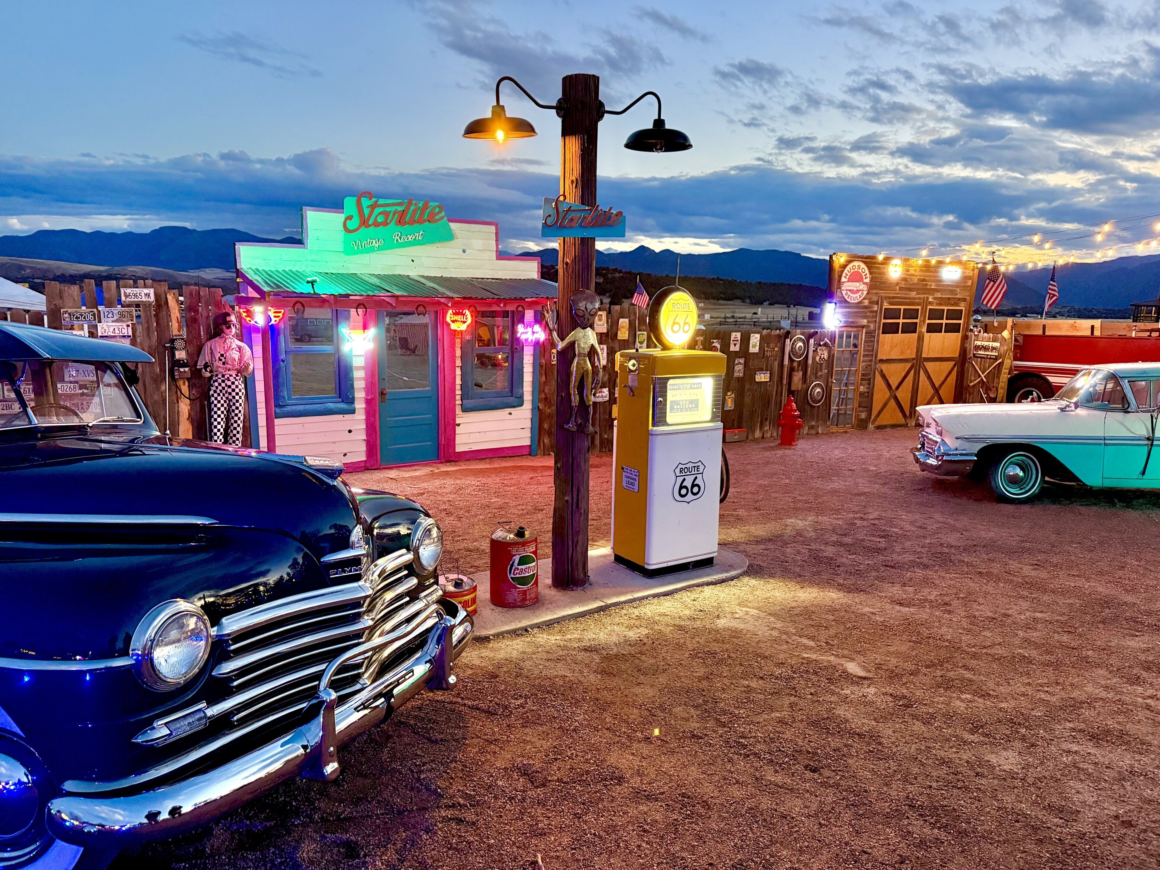 A vintage-themed area with a neon sign for 'Starlite Vintage Resort,' a vintage gas pump, and classic cars.