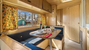 Ein kompaktes Wohnmobil-Interieur mit einer Küchenzeile, Essbereich und Sitzgelegenheiten.