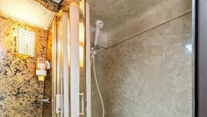 Ein Badezimmer mit einer Glaskabine zur Dusche, einem Marmorwaschbecken und einem Handtuchhalter.