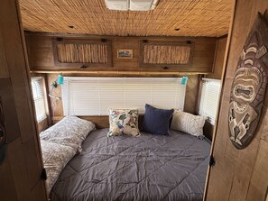 Un ambiente acogedor con una cama, almohadas y un adorno decorativo en la pared.