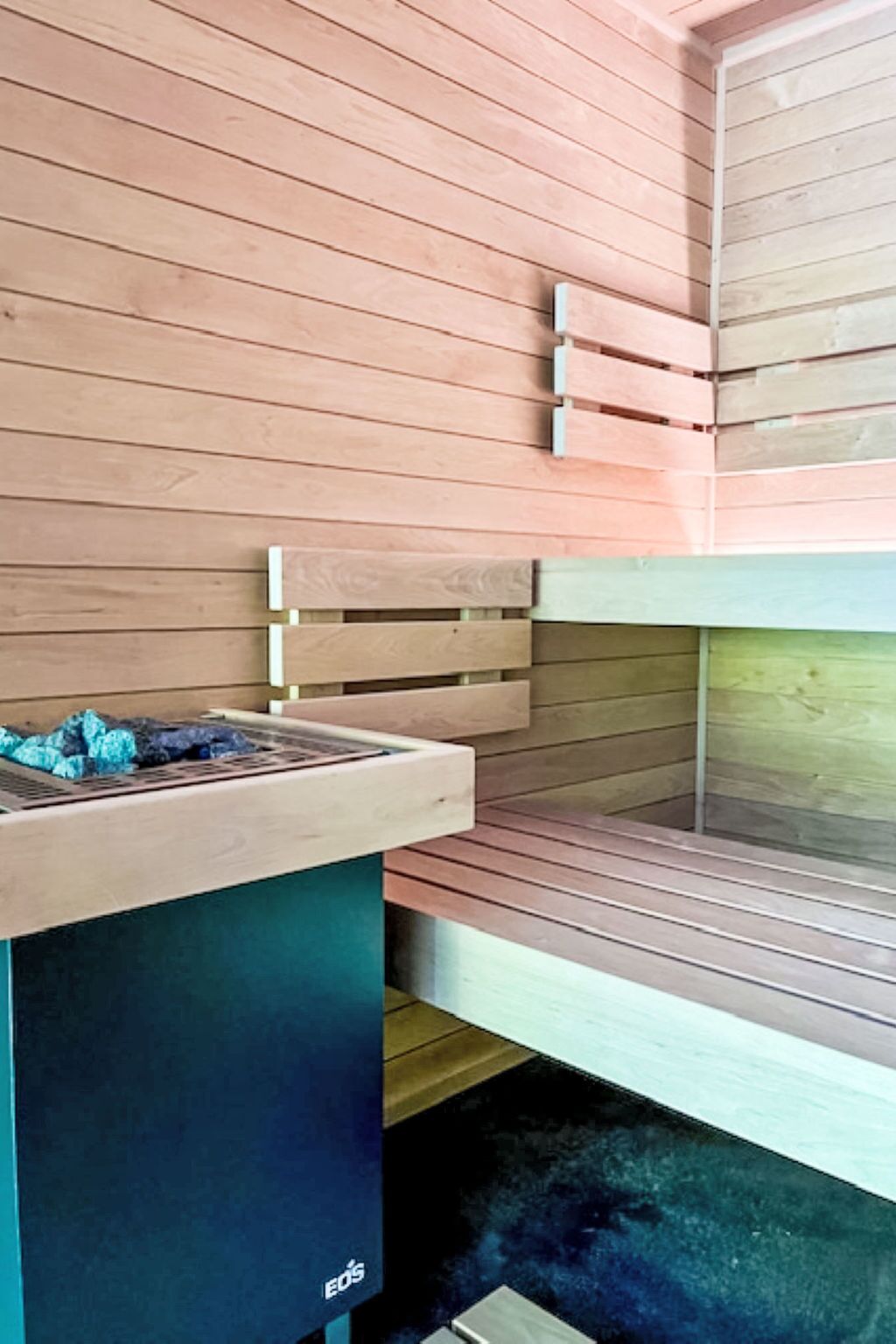 Un sauna avec des bancs en bois et une banquette.