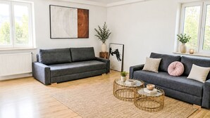 A modern living room with two sofas, a coffee table, and a rug. - 1OG "R" Helle 80m² 3-Zimmer Wohnung näh by Interhome (Freilassing)