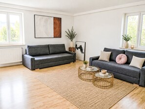 Ein modernes Wohnzimmer mit zwei Sofas, einem Couchtisch und einem Teppich.