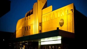 En byggnad med en skylt som visar ordet ”TEATER” och en stor, väl synlig skylt med en ”SOL” på toppen.