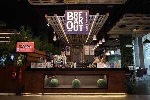 Un café y restaurante con mostrador de madera, extintores y una pizarra de menú.