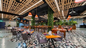 A modern restaurant with a geometric patterned floor, wooden ceiling beams, and orange pendant lighting. - Standard | Park Regis BB | Business Bay Base, Outdoor Pool, Spa Reset (Dubai)
