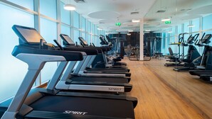 A gym with treadmills, mirrors, and exercise equipment.