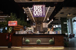 A cafe and restaurant with a wooden counter, fire extinguishers, and a menu board.
