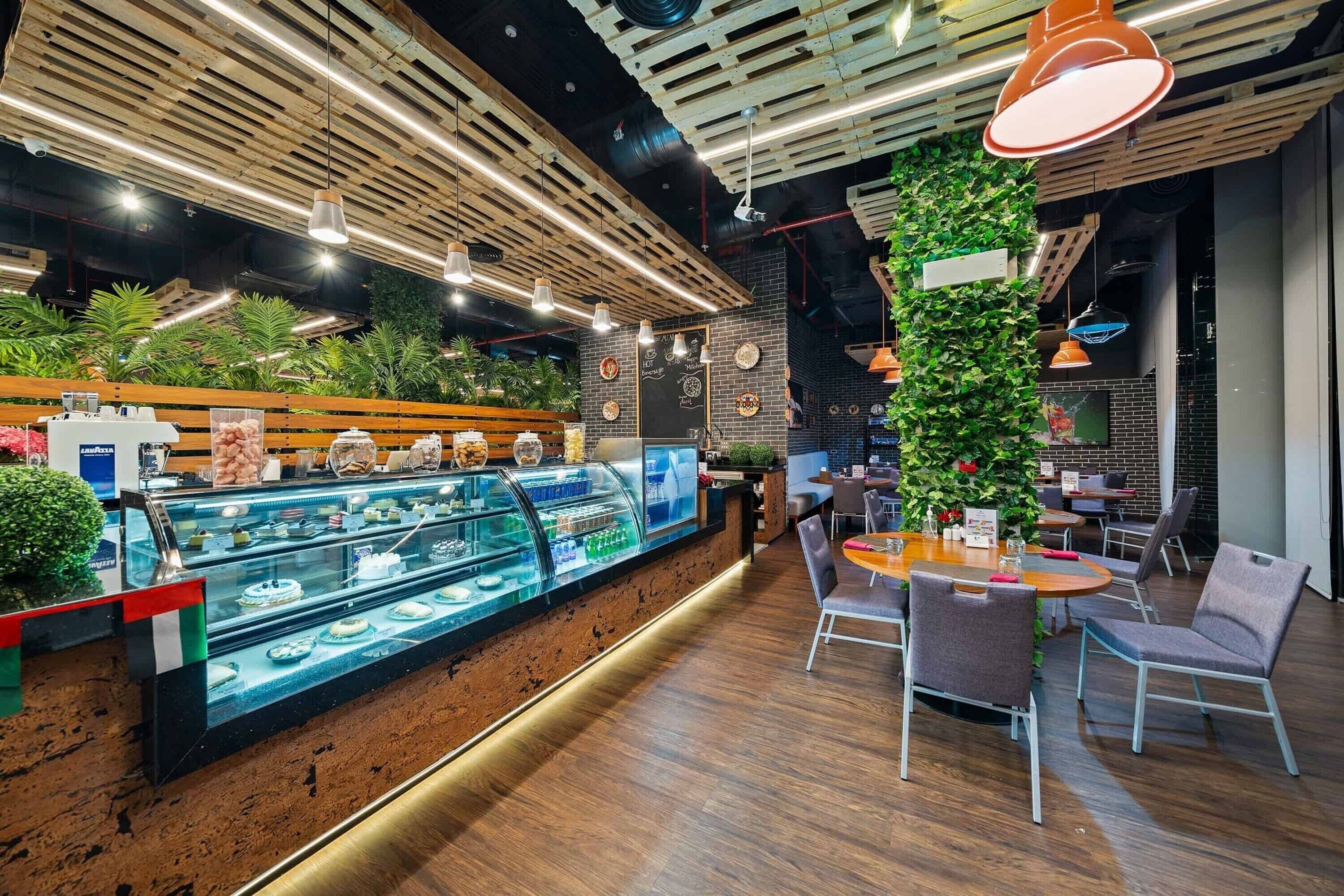 Een modern café interieur met een houten toonbank, zithoek en decoratieve planten.