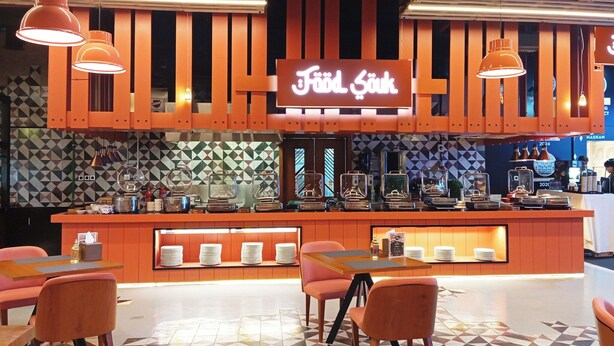 Un restaurante con barra, diversas opciones de asientos y piso de baldosas estampadas.