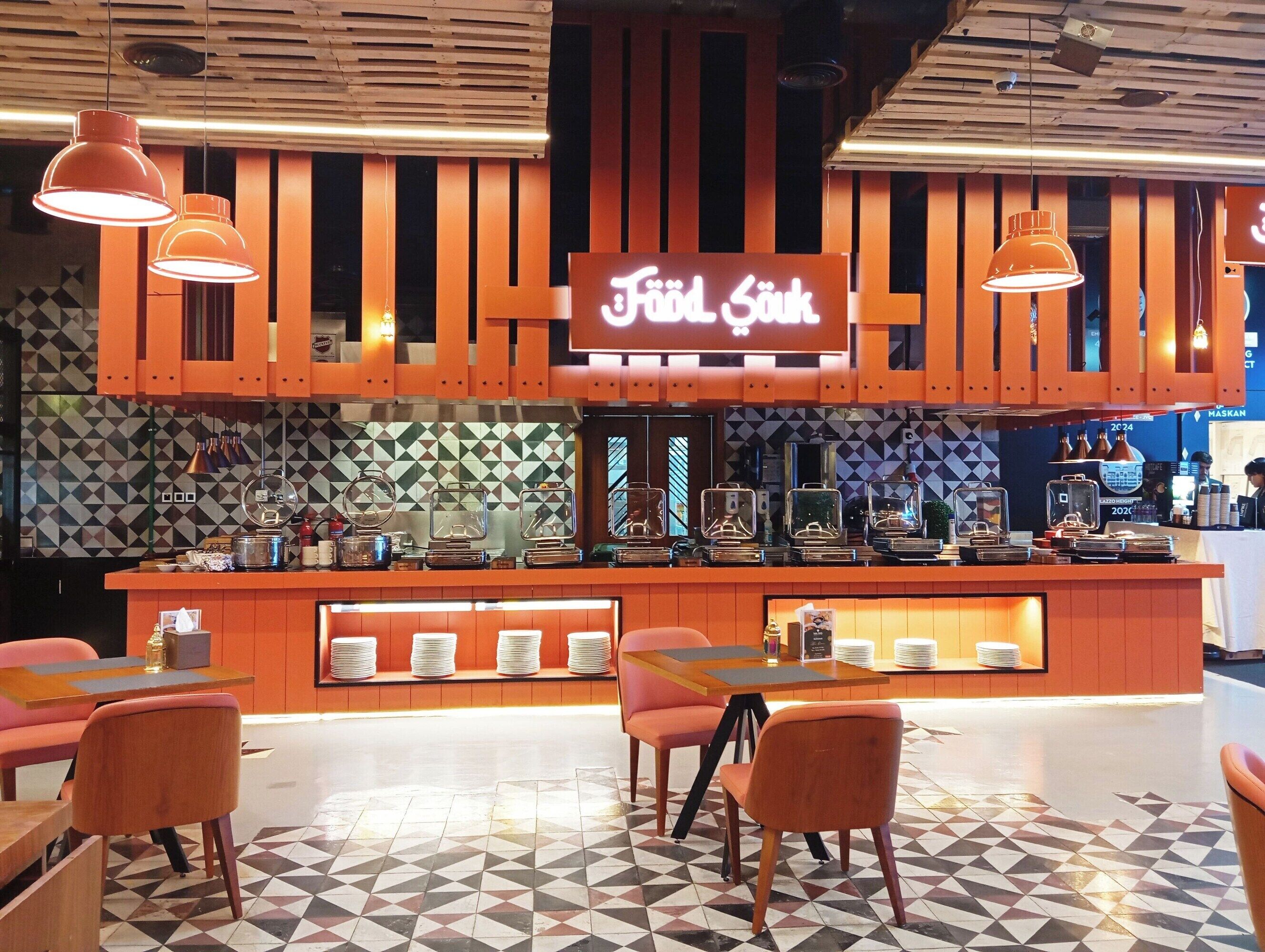 Un restaurant doté d’un bar, de plusieurs espaces pour s’asseoir et d’un sol recouvert de carreaux décoratifs.
