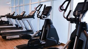 Varias cintas de correr de la marca SPIRIT en un gimnasio con ventanas amplias y piso de madera.