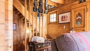 Ein Holzinnenraum mit Treppe, Koffer und Bett.