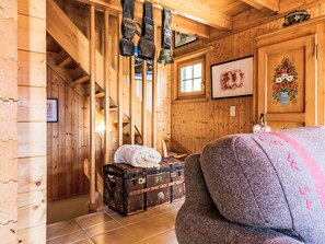 Ein Holzinnenraum mit Treppe, Koffer und Bett.