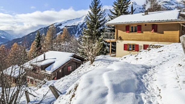 Un paysage de montagne enneigé, avec un bâtiment en bois et un télésiège.