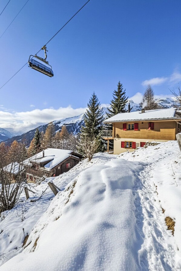 A snow-covered mountain landscape with a wooden building and a ski lift. - La Marmotte by Interhome (Bellwald)
