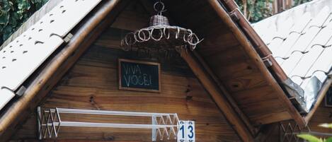 A wooden building with a sloped roof, a sign with the number 13, and a hanging light fixture.
