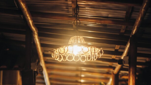 A corridor with a hanging light fixture and wooden beams. - Glamping Med (Porto Seguro)