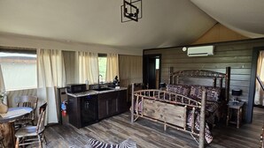 Ein geräumiges Zimmer mit einem hölzernen Bett, einem Essbereich und einer Küche.
