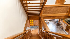Una escalera de madera con un muro de ladrillo y una zona de estar debajo.