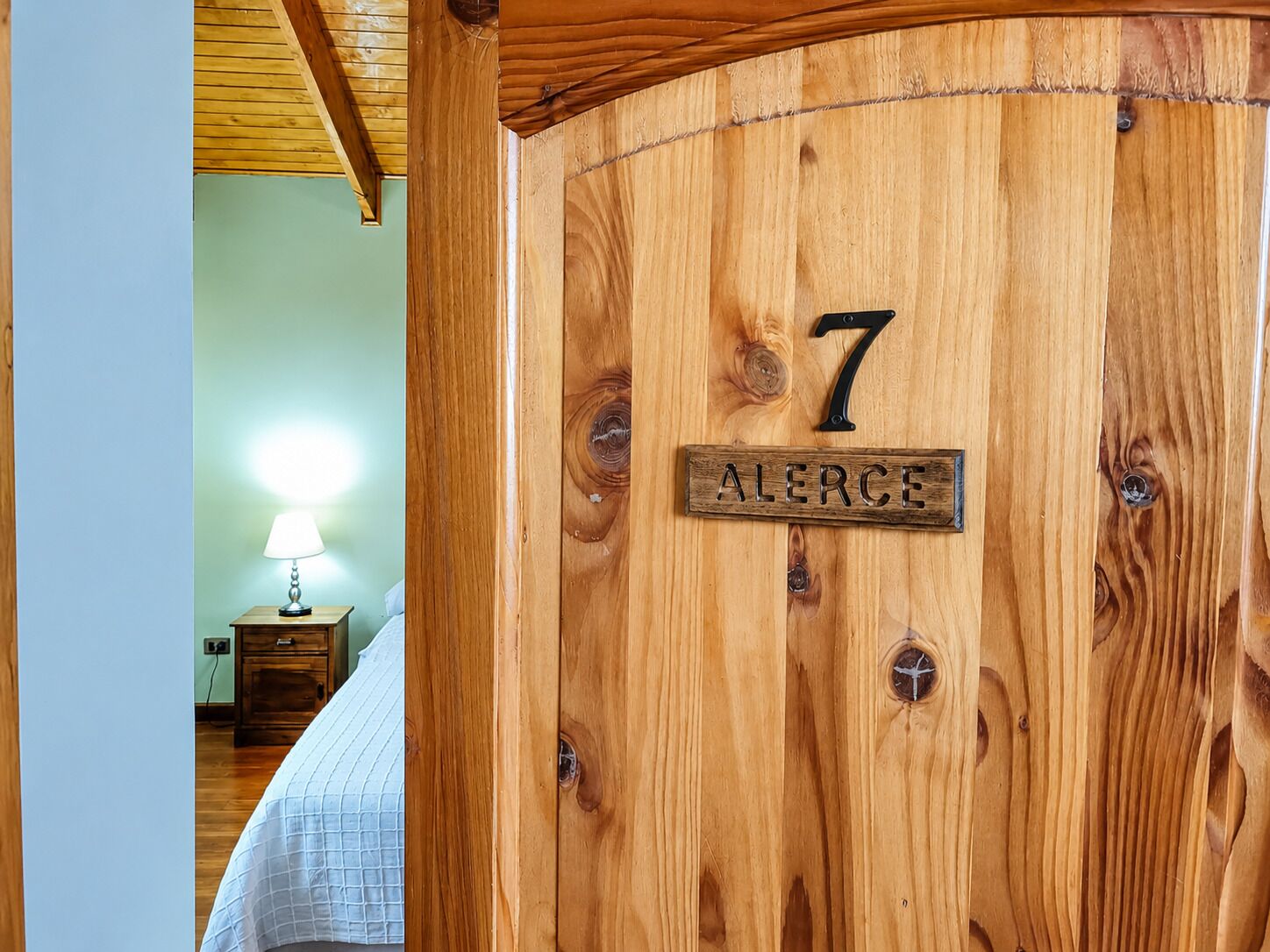 A wooden door with a number '7' and the name 'ALERCE' on it.