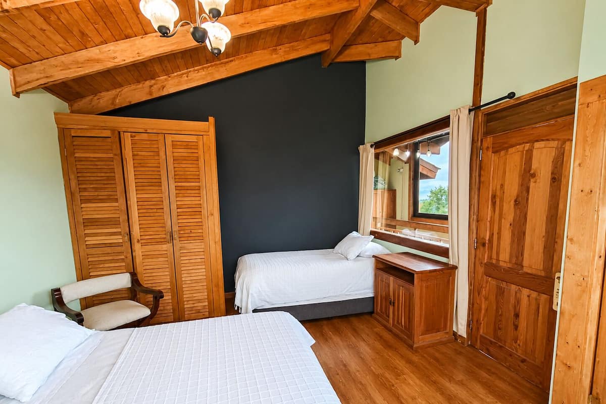 Un dormitorio con dos camas, muebles de madera y un espejo grande.