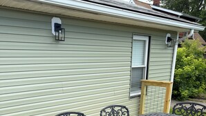 A patio table with chairs, a wooden deck, and a house with a light green exterior. - Charming recently renovated house with AC, WiFi, in The Ashtabula Harbor (Ashtabula)