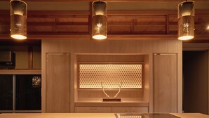 Una cocina con armarios de madera, estufa integrada e iluminación colgante.