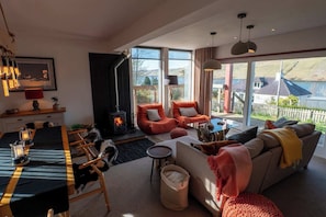 Un salon chaleureux avec une cheminée, des sièges confortables et un coin repas.