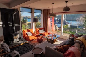 Un salon moderne avec une cheminée, de grandes fenêtres et un coin salon confortable.